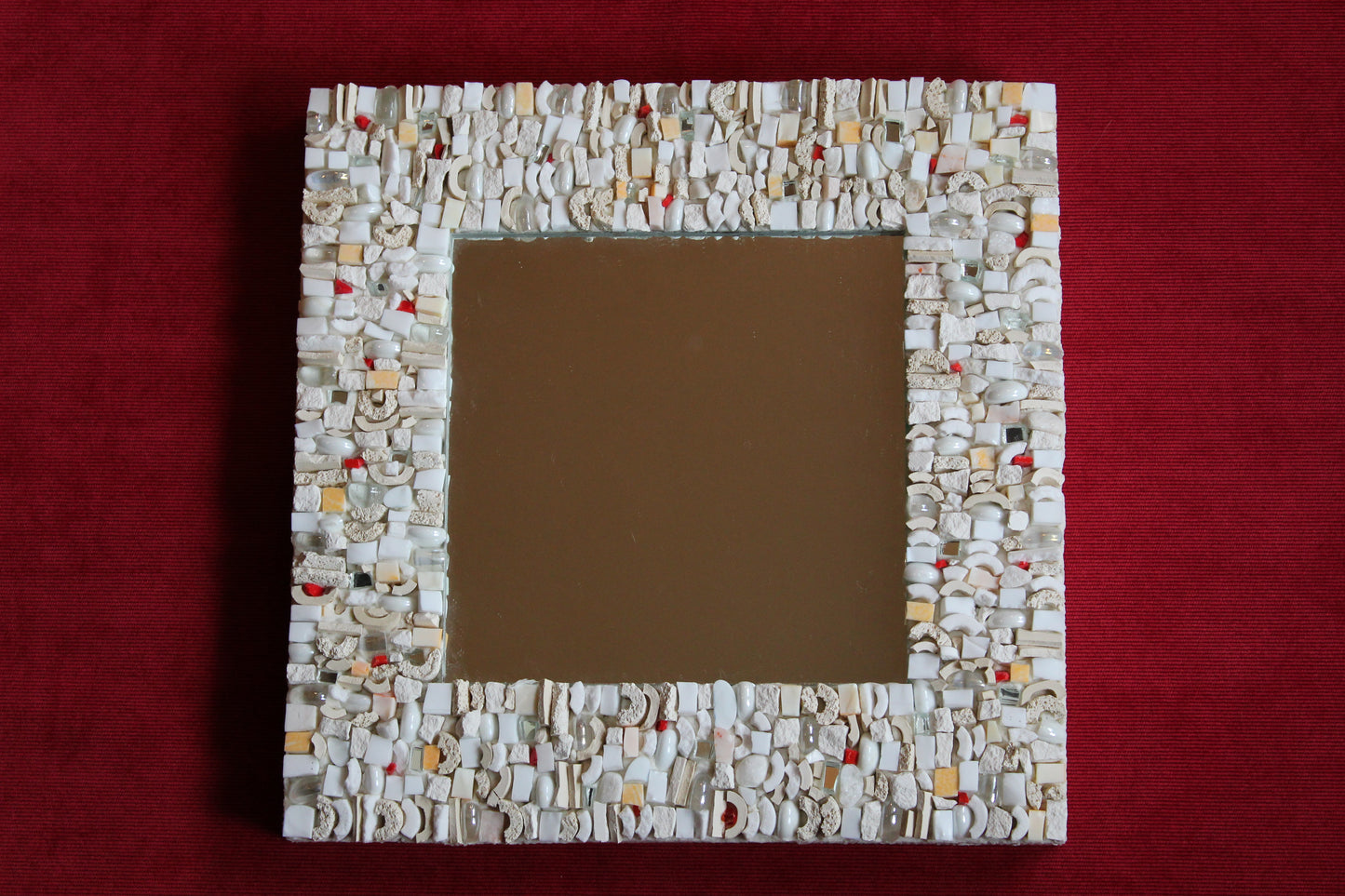 Specchio mosaicato bianco con smalti veneziani bianchi, smalti ceramicati, pietra bianca, ceramica grezza, vetri madreperlati, punti di smalto veneziano rosso e specchietti, dimensioni 25x25 cm, base in legno