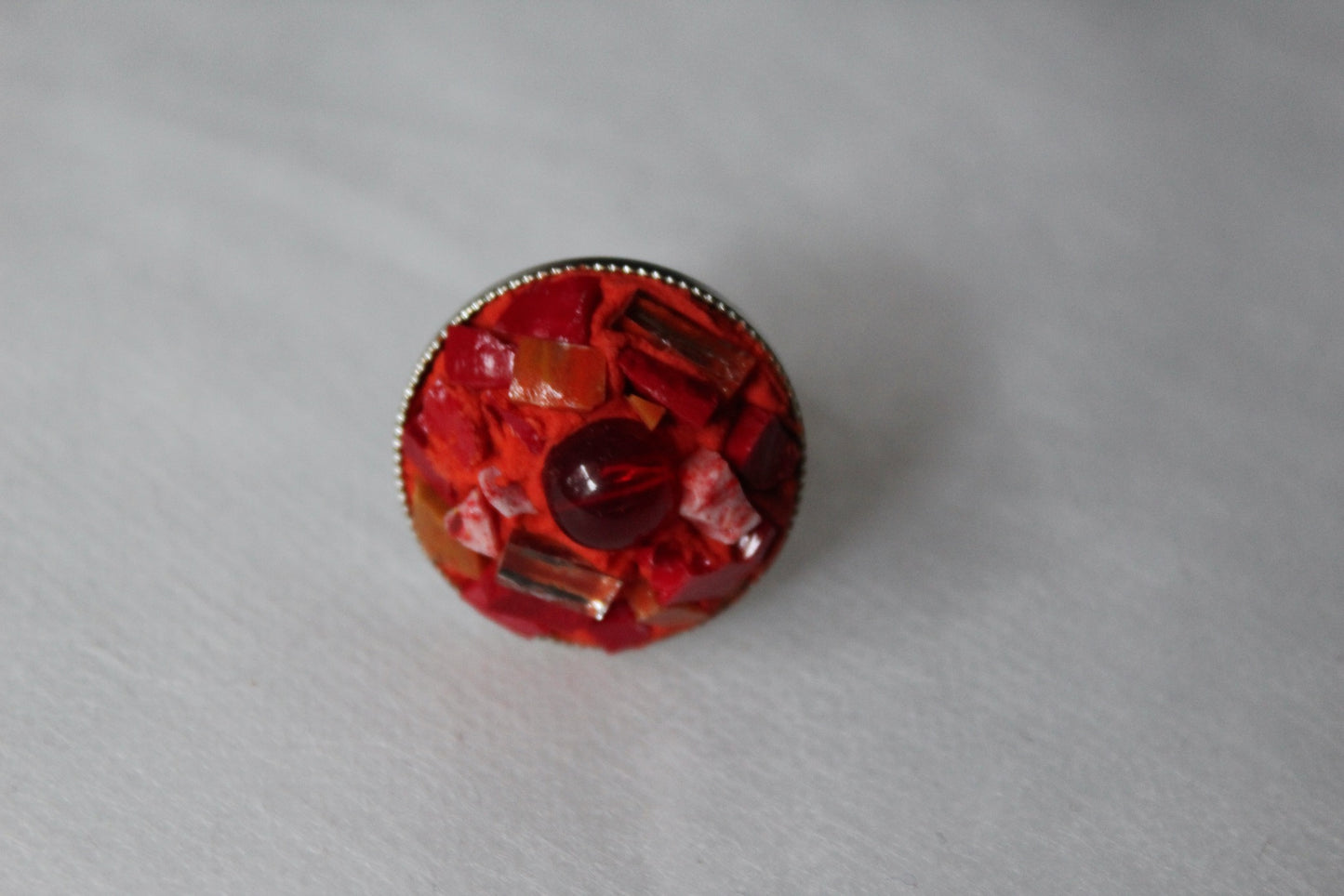 Anello in micromosaico rosso con specchietti su sfondo bianco vista frontale