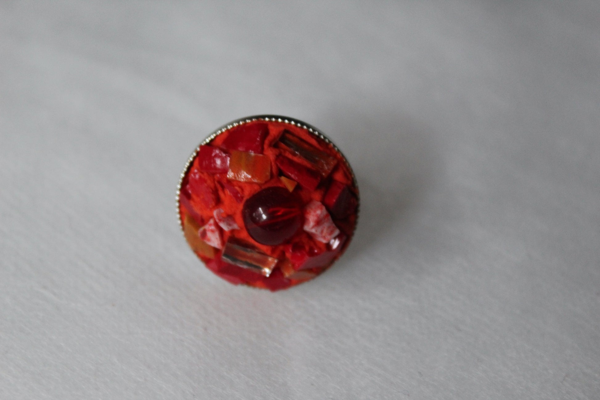 Anello in micromosaico rosso con specchietti su sfondo bianco vista frontale