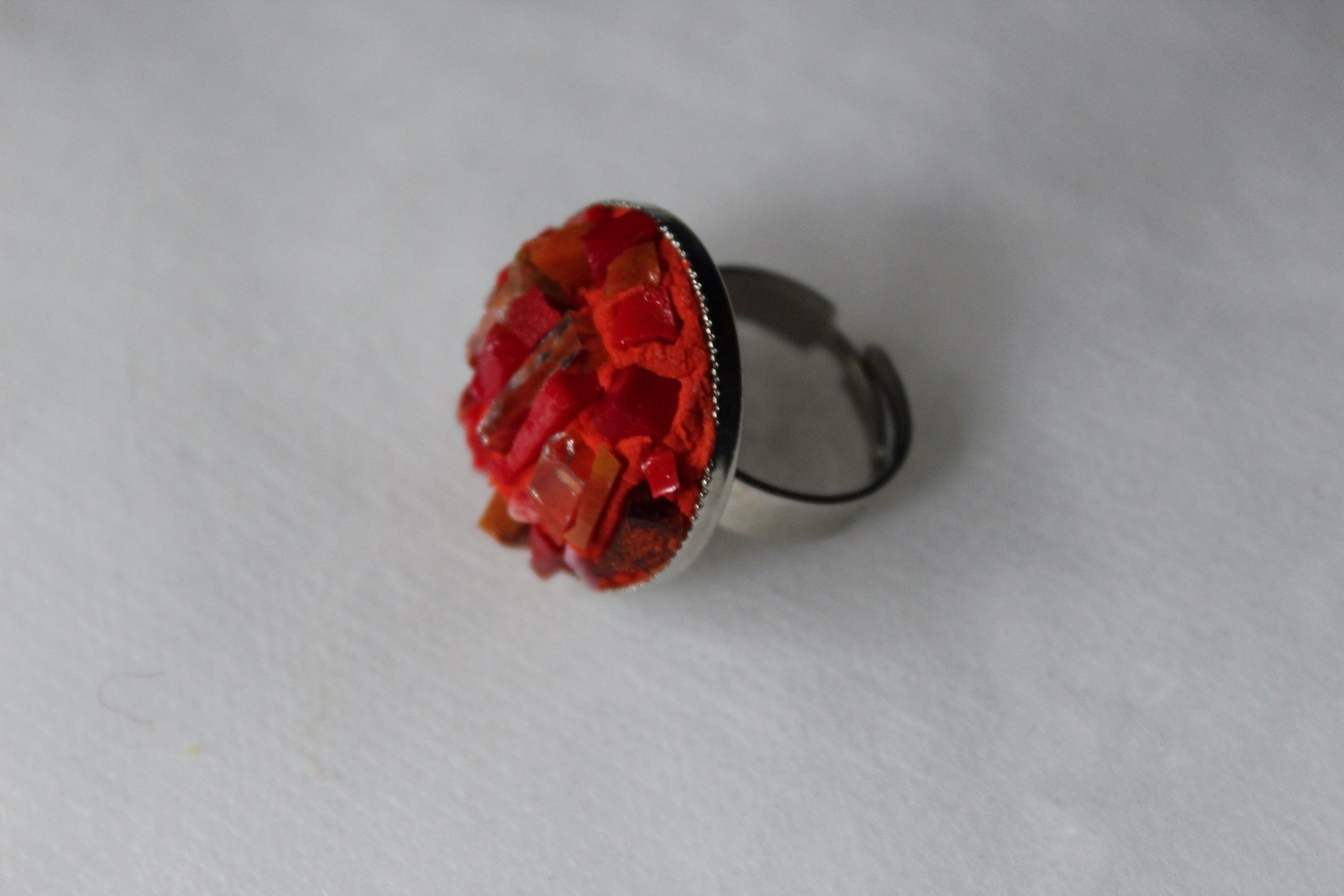 Anello in micromosaico rosso con specchietti su sfondo bianco vista laterale sinistra