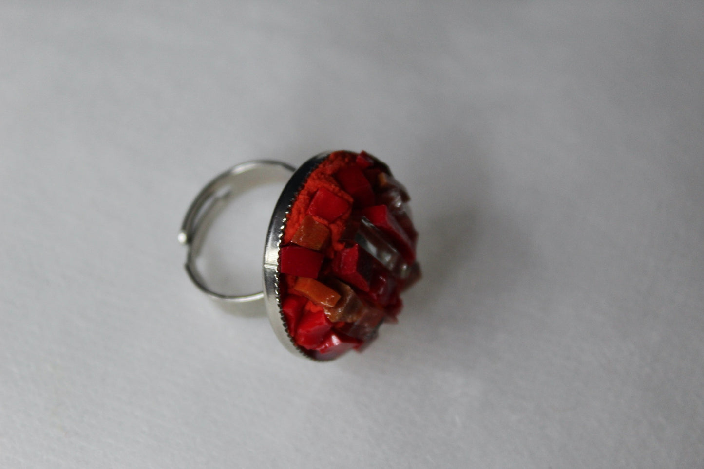 Anello in micromosaico rosso con specchietti su sfondo bianco vista laterale destra