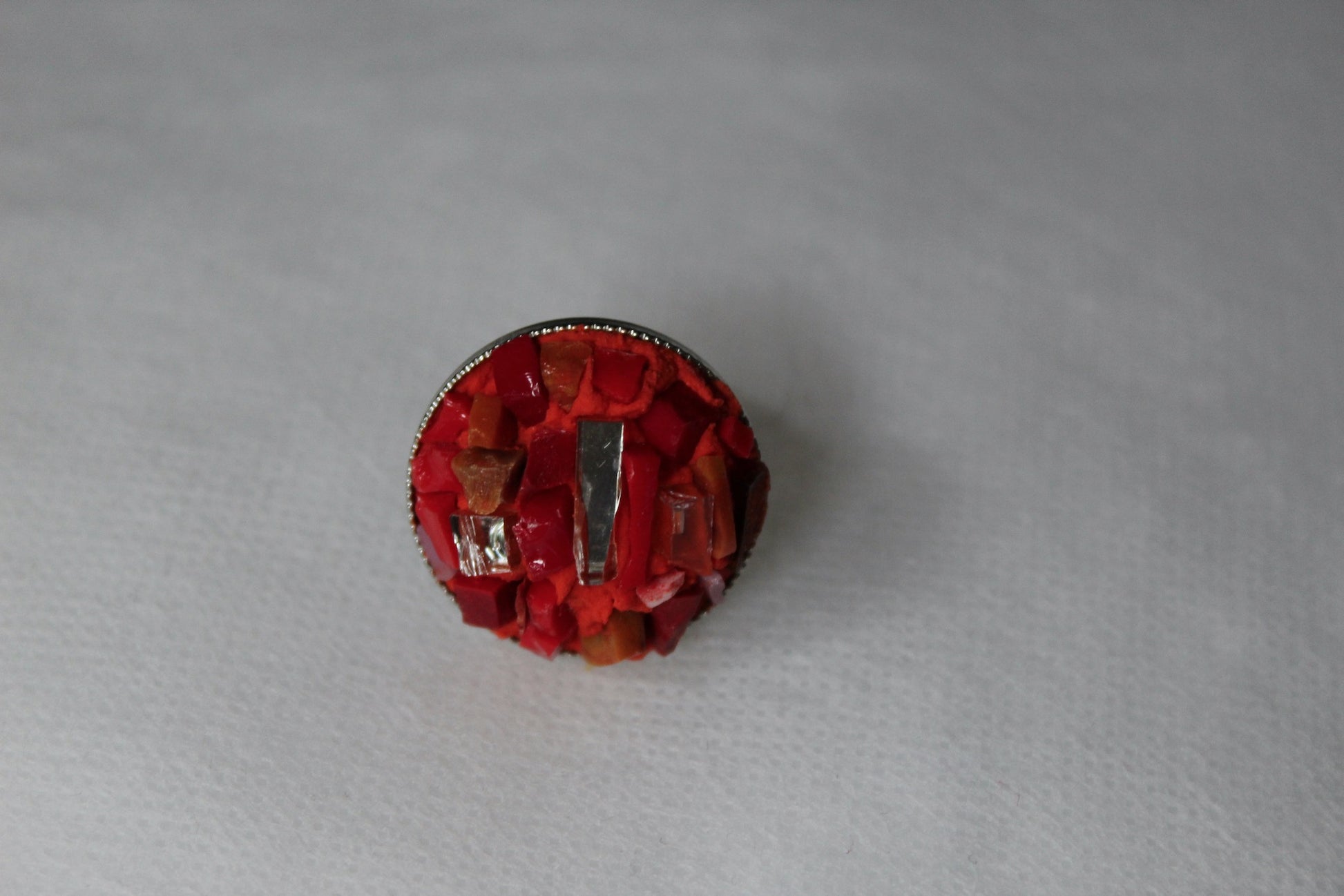 Anello in micromosaico rosso con specchietti su sfondo bianco vista frontale