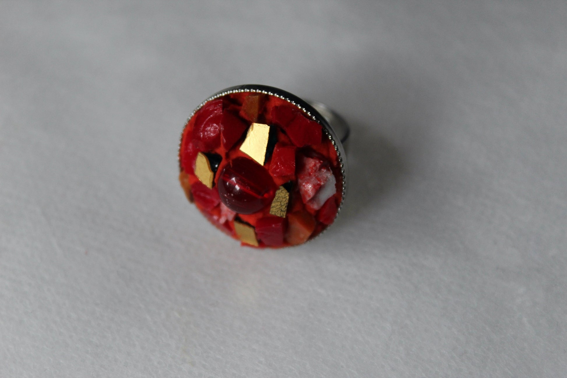 Anello in micromosaico rosso e oro con perla su sfondo bianco vista frontale