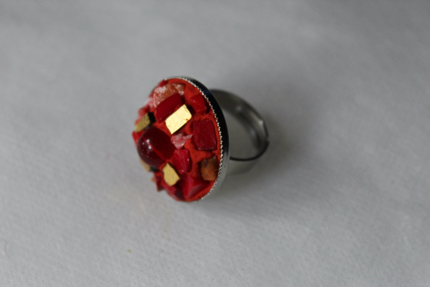 Anello in micromosaico rosso e oro con perla su sfondo bianco vista laterale sinistra