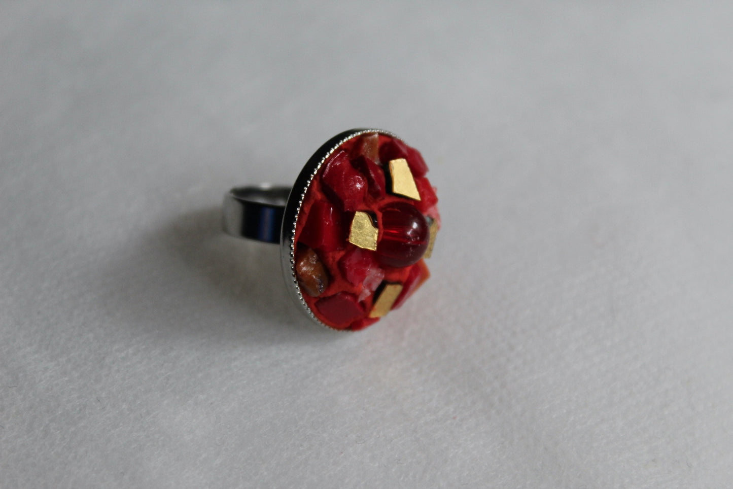 Anello in micromosaico rosso e oro con perla su sfondo bianco vista laterale destra