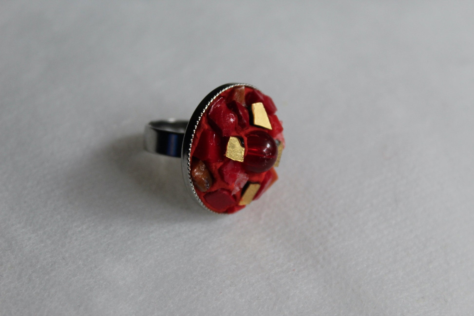Anello in micromosaico rosso e oro con perla su sfondo bianco vista laterale destra