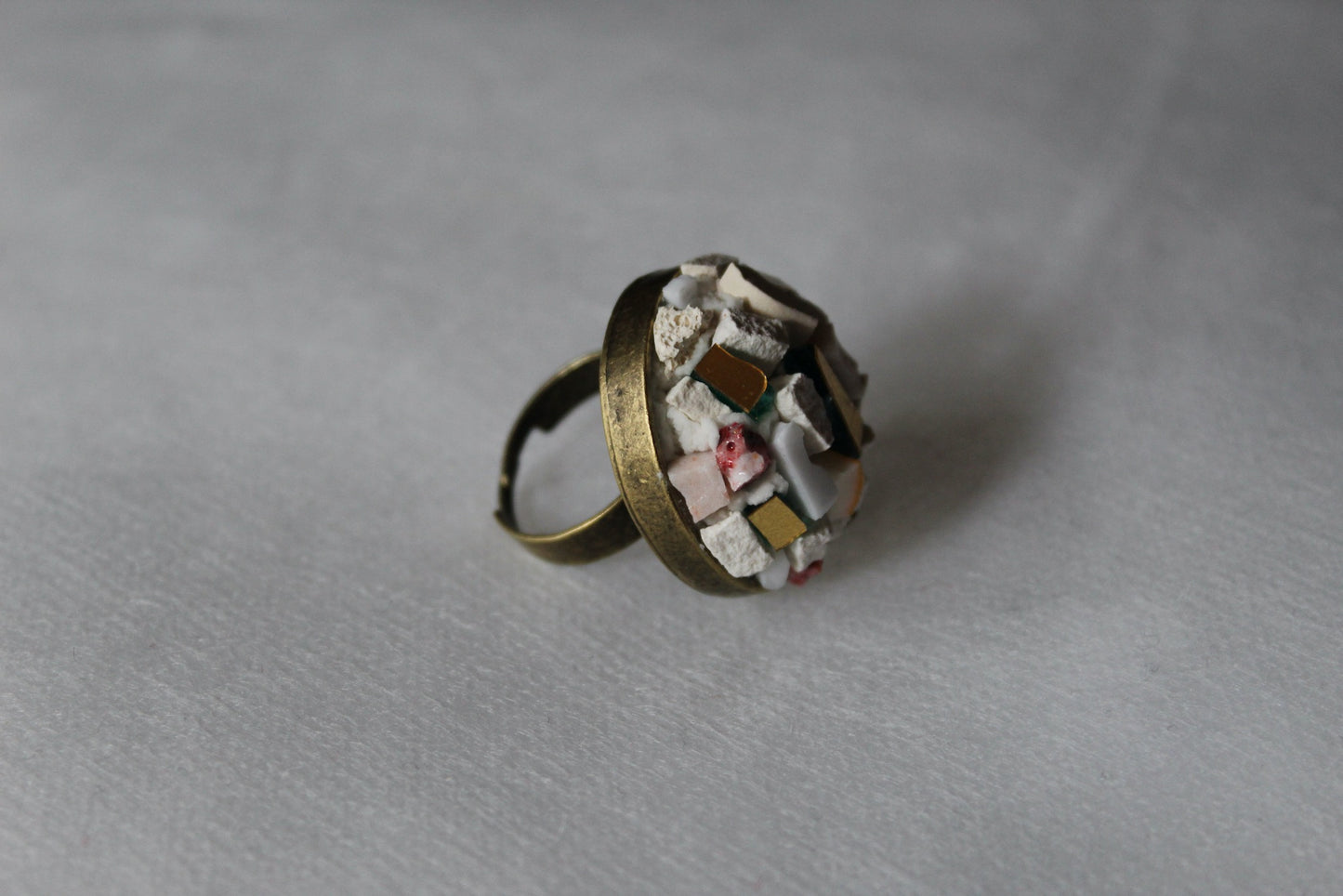 Anello in micromosaico bianco base ottone su sfondo bianco vista laterale destra