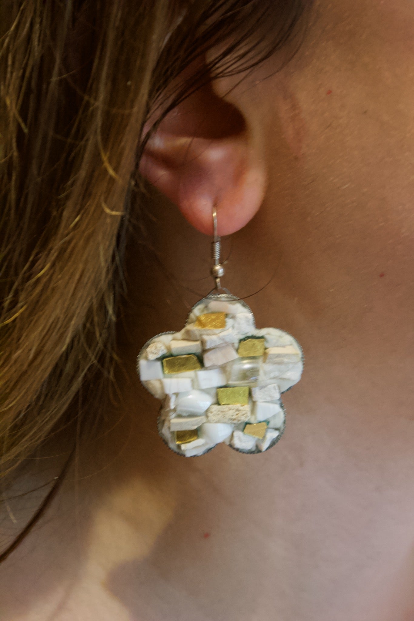 Orecchini a fiore bianchi in micromosaico indossati dettaglio