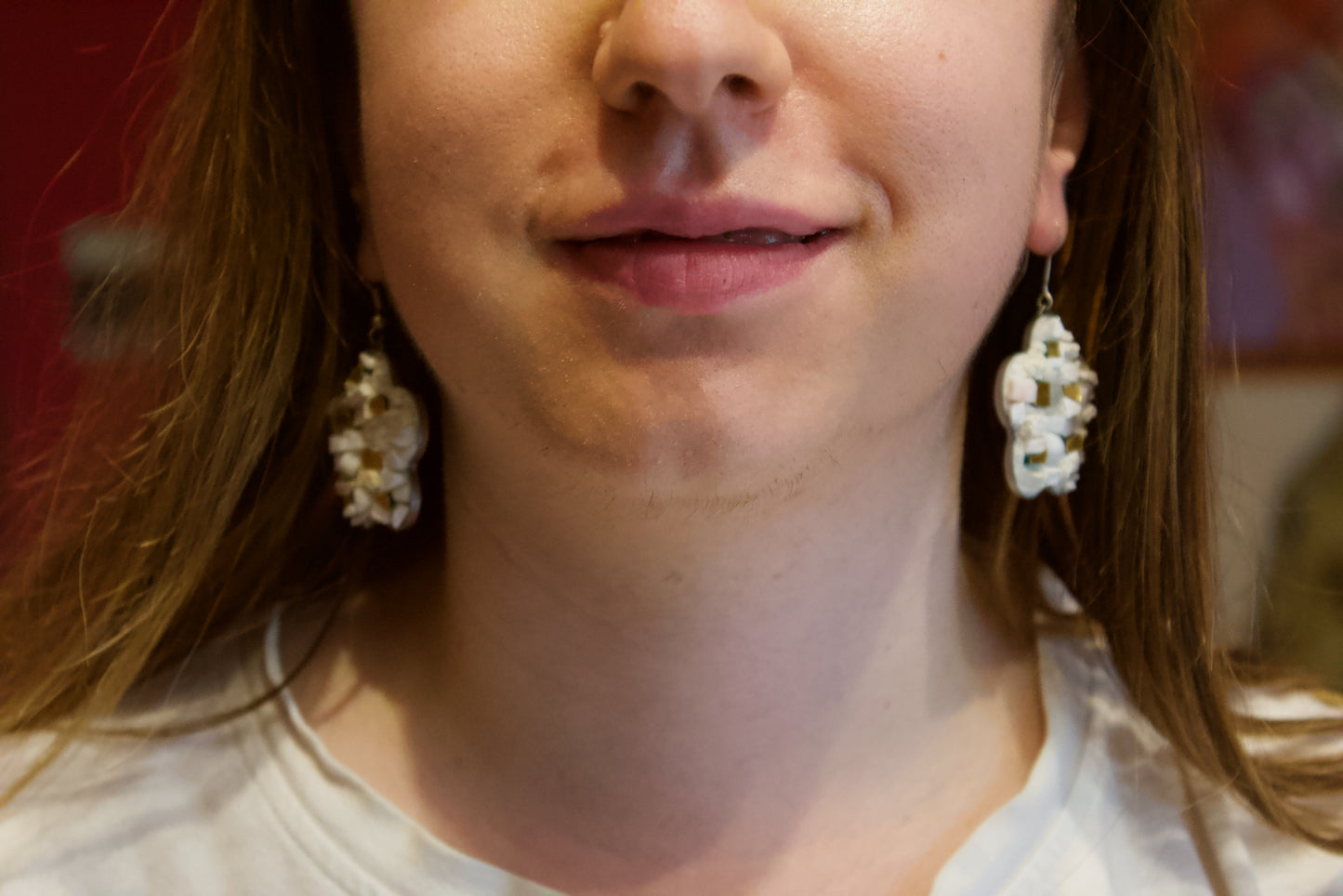 Orecchini a fiore bianchi in micromosaico indossati vista frontale