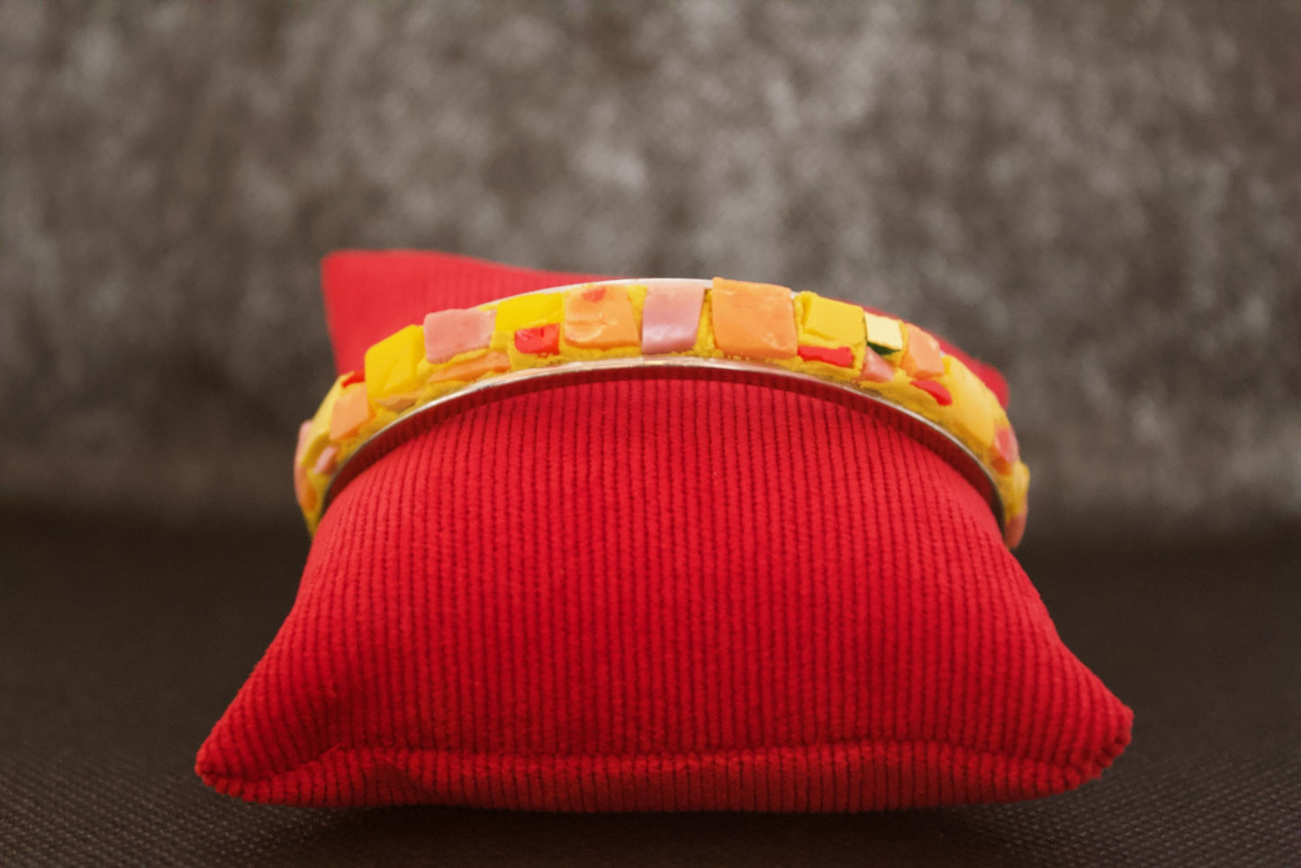 Bracciale giallo arancio in micromosaico su sfondo nero vista frontale