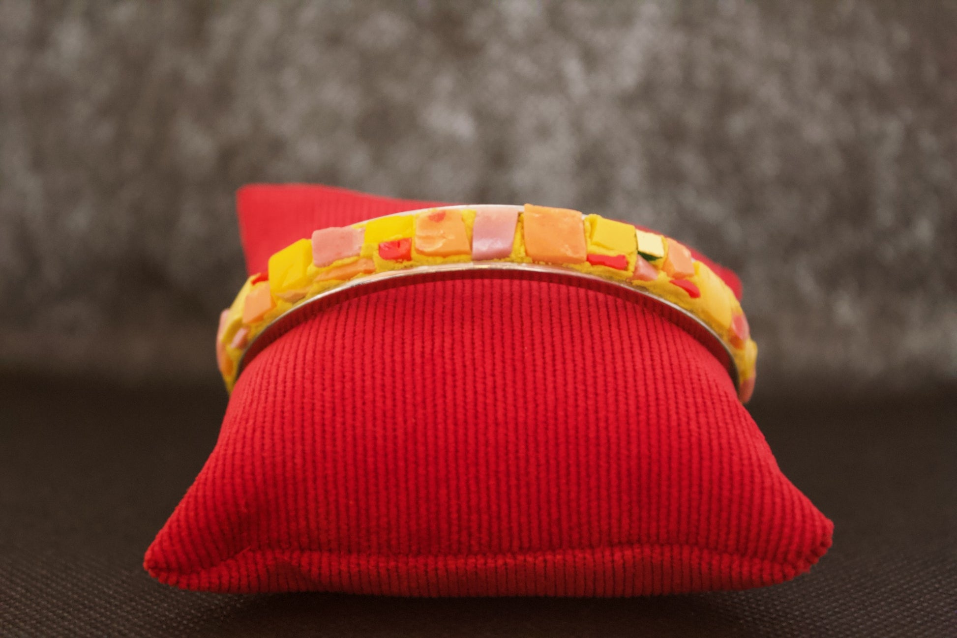 Bracciale giallo arancio in micromosaico su sfondo nero vista frontale