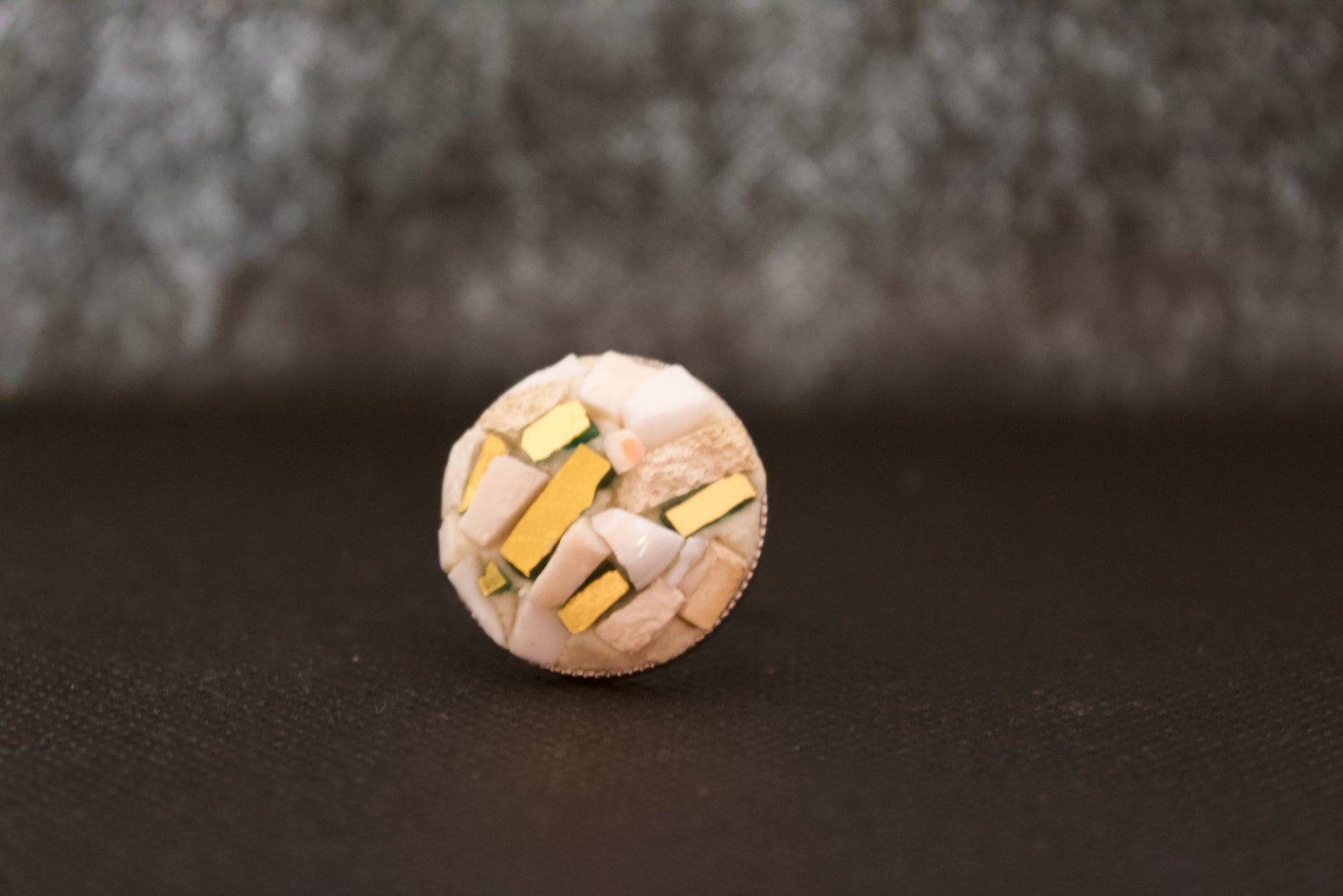 Anello micromosaico con oro puro su sfondo nero vista frontale