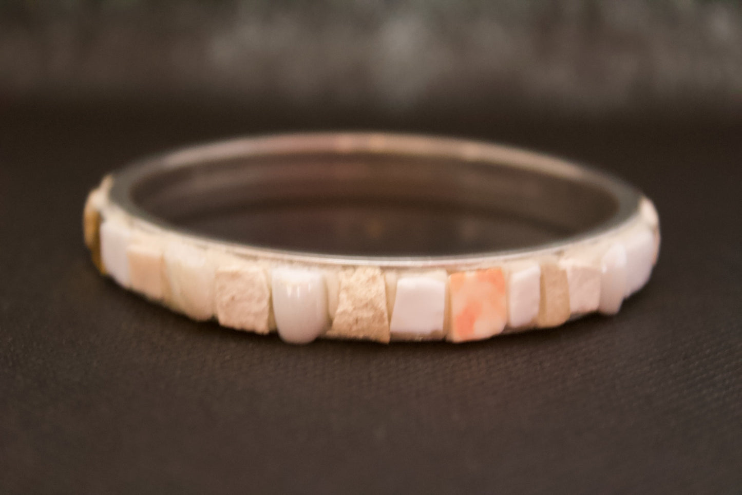 Bracciale bianco in micromosaico con oro puro su sfondo nero dettaglio vista frontale