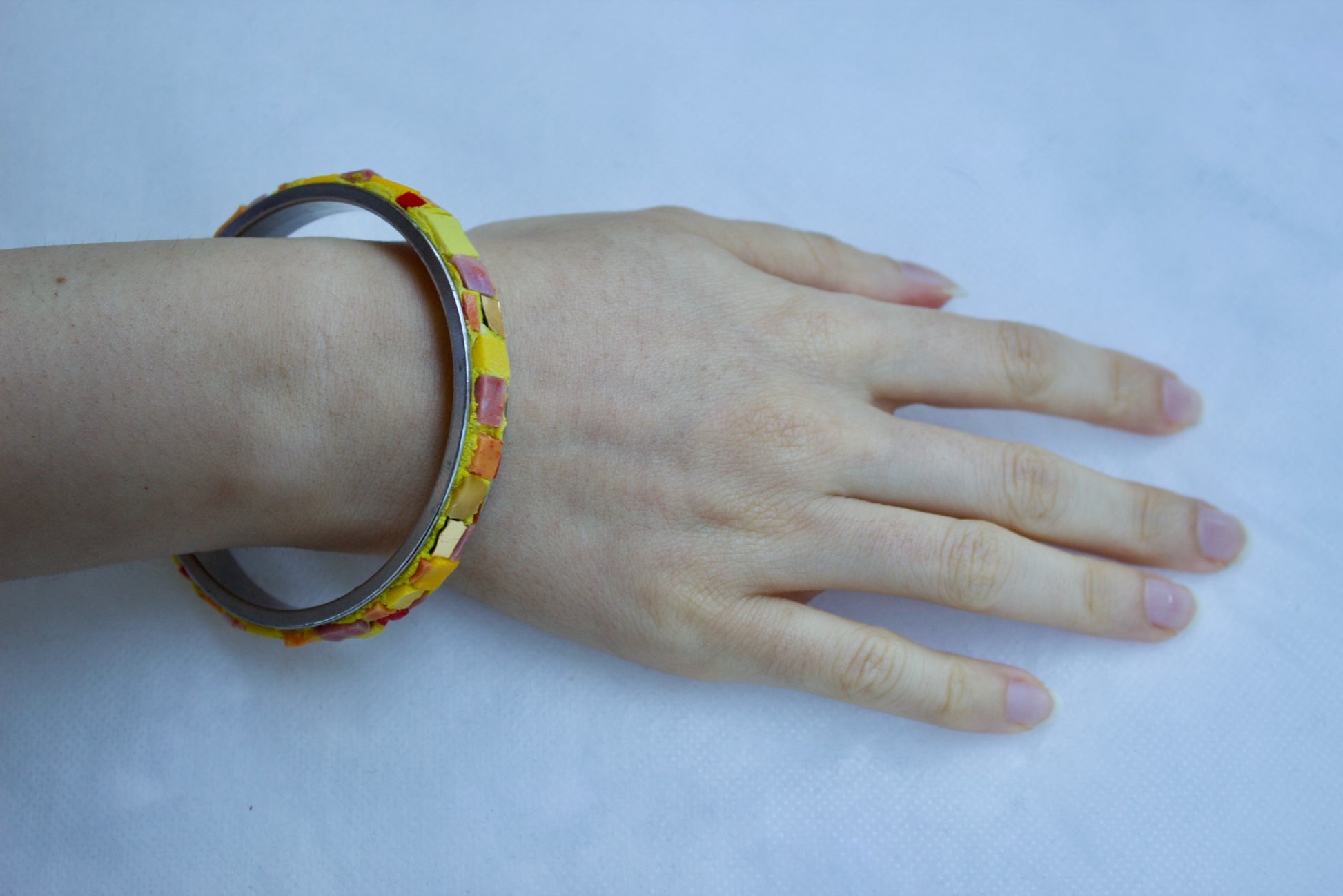 Bracciale giallo arancio in micromosaico sul polso