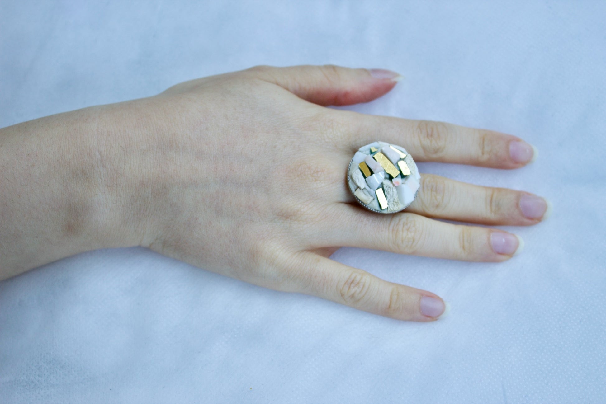 Anello micromosaico con oro puro indossato su mano