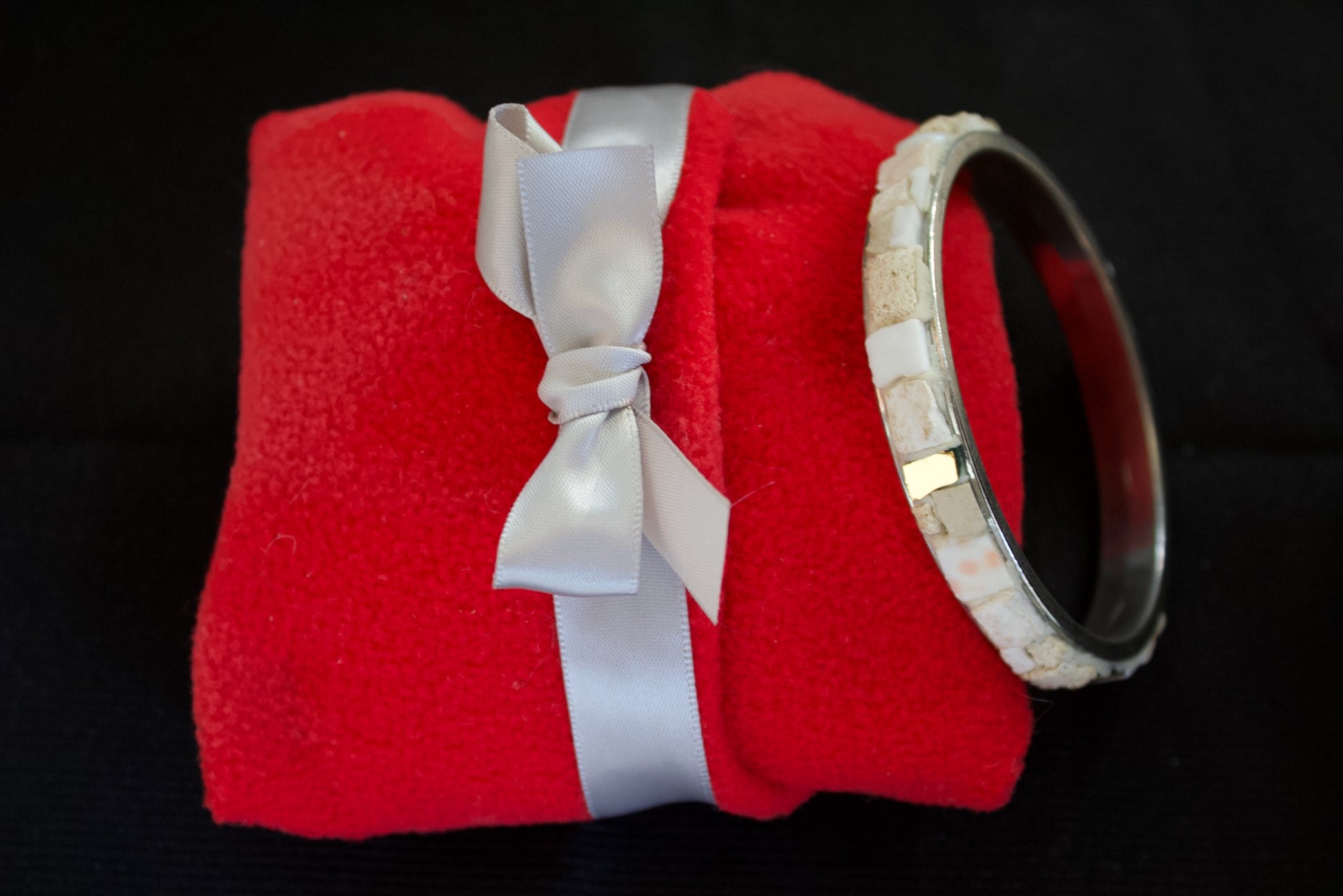 Bracciale bianco in micromosaico con oro puro su pacchetto in panno rosso morbido con fiocco bianco