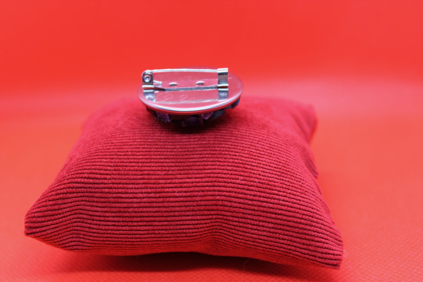 Spilla tonda blu in micromosaico con oro su sfondo rosso retro